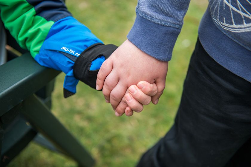 Nahaufnahme zweier Hände, die einander greifen.